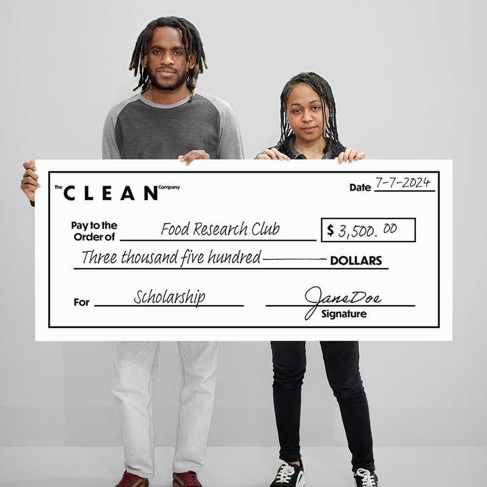 A man and a woman holding an oversized check for a scholarship